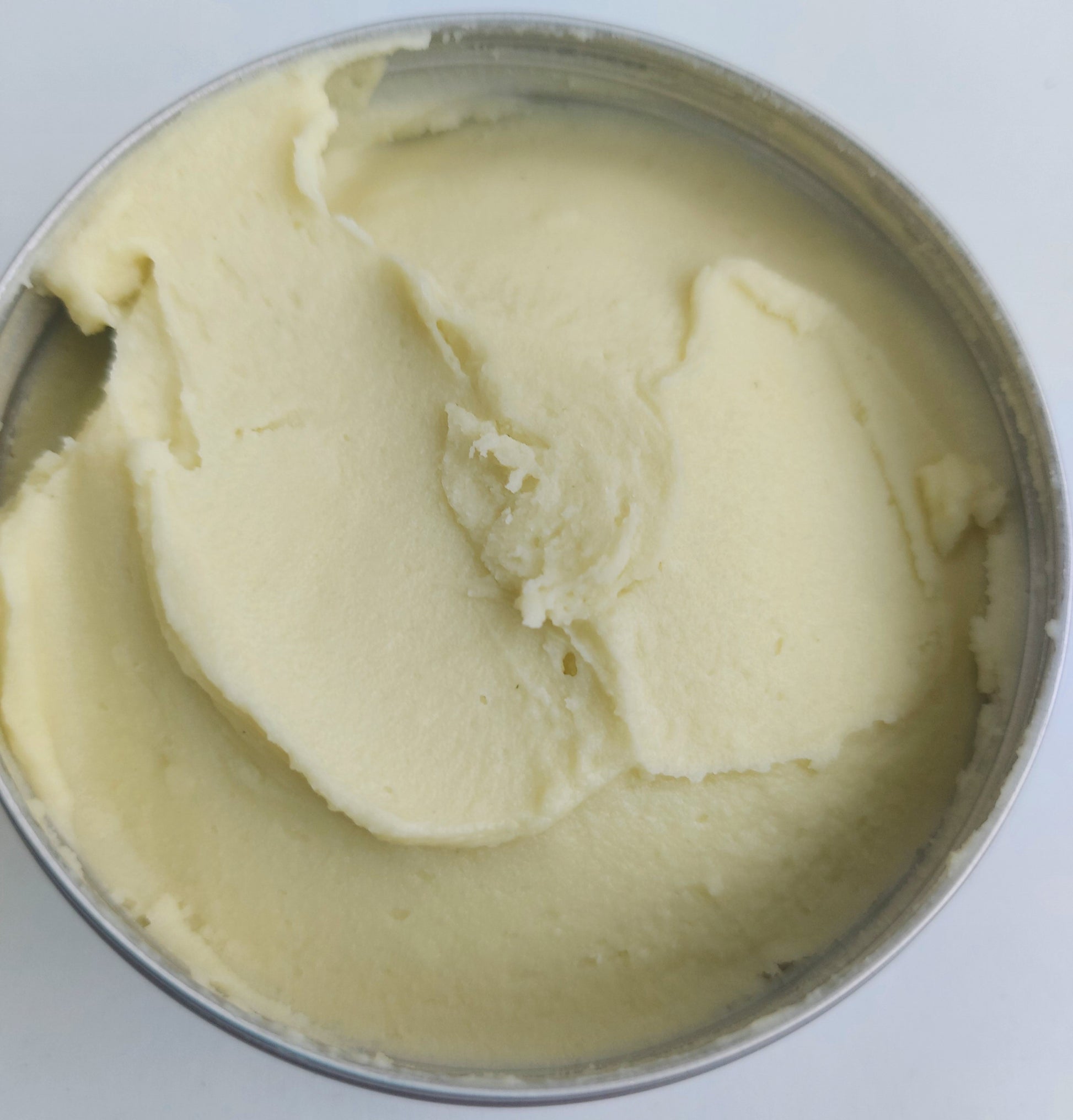 Mango and Lime Body and Heel Butter with tin lid off showing rich moisturising butter.