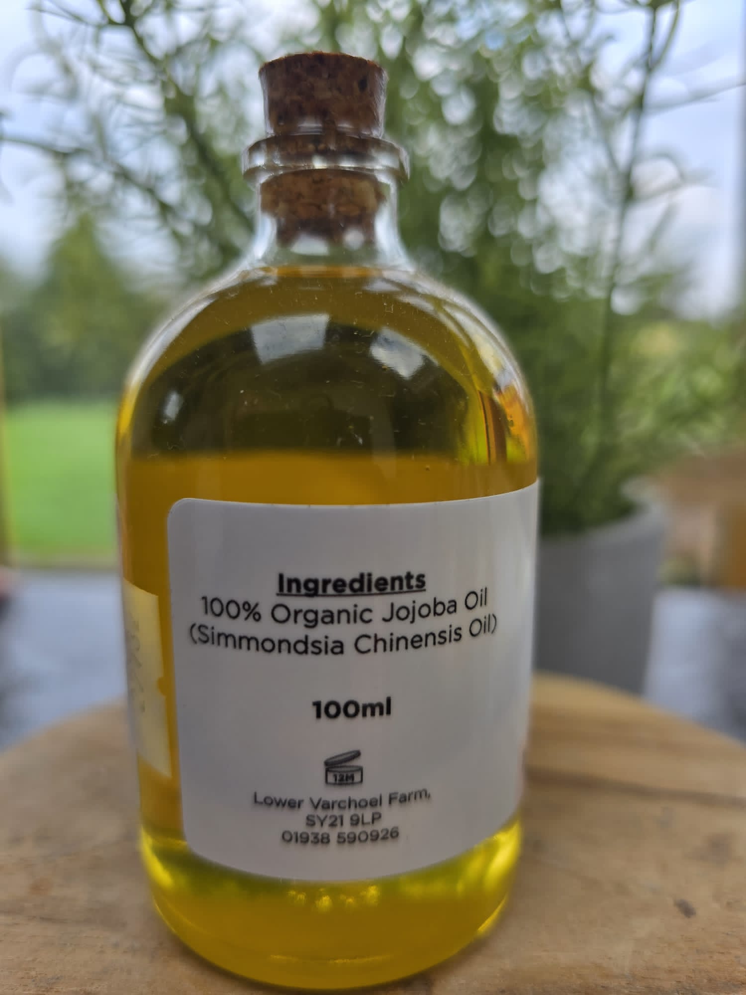 Bottle of skincareBOOtique Organic Jojoba Oil showing ingredients label